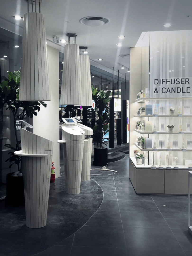 Modern store interior with sleek, tall white displays and a shelf labeled 