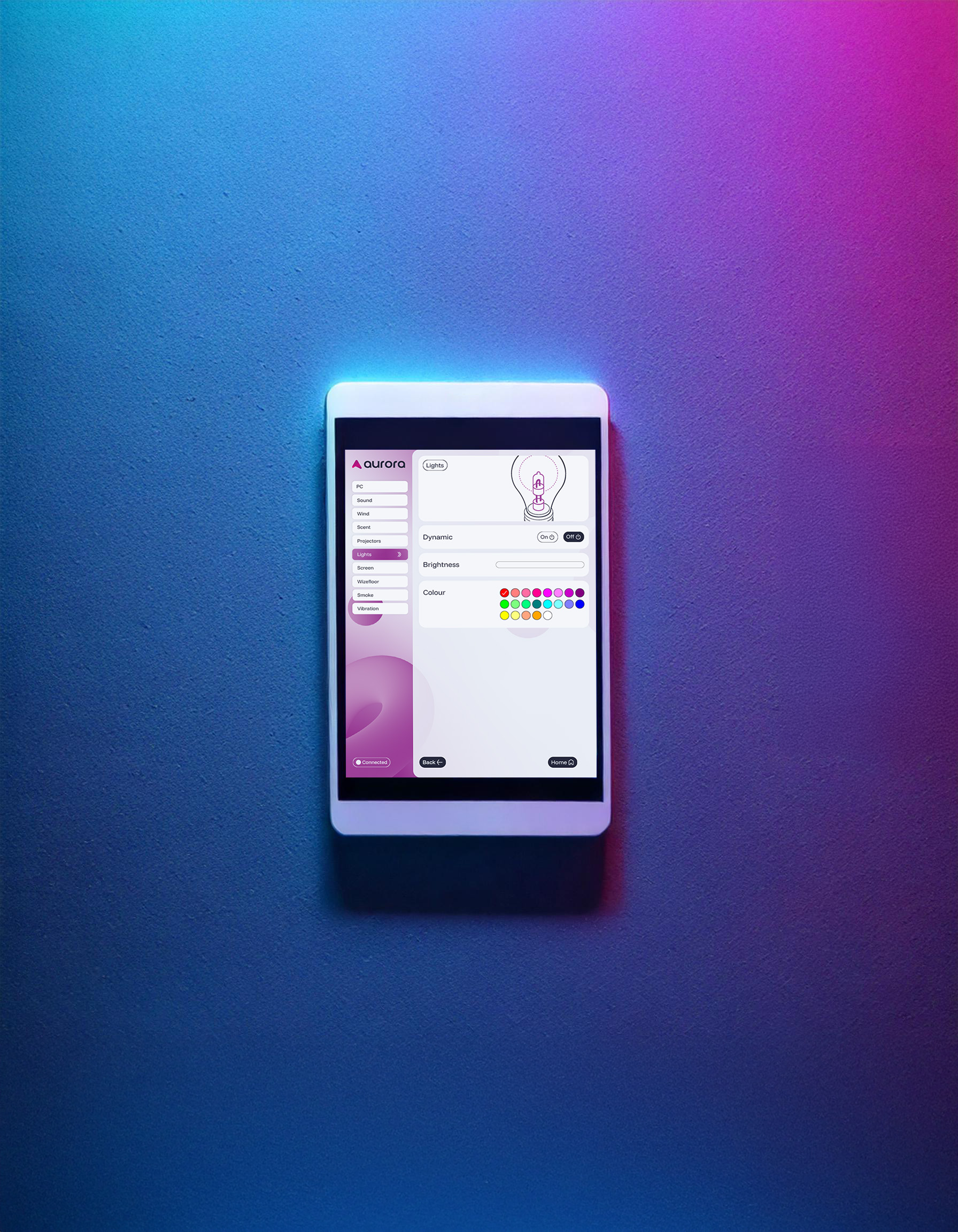 A tablet on a gradient blue and pink wall displays a lighting control app with settings for dynamics, brightness, and colour options in vivid hues.